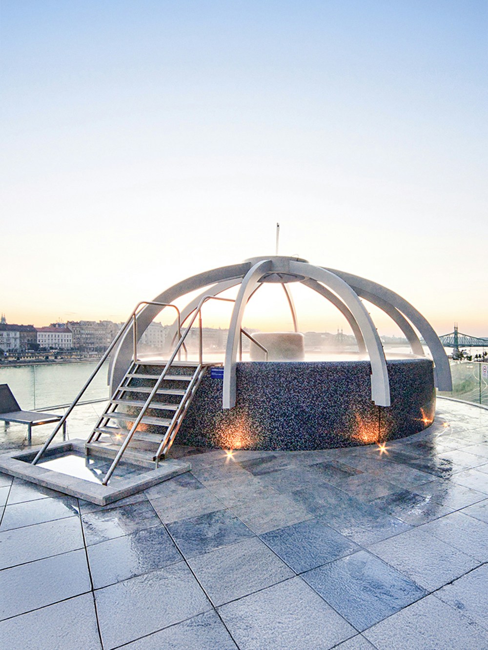 Rooftop pool at Rudas Bath in Budapest with city skyline in the background.