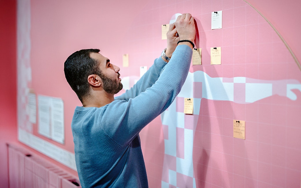 Guest placing notes on an interactive exhibit at NEMO Science Museum.