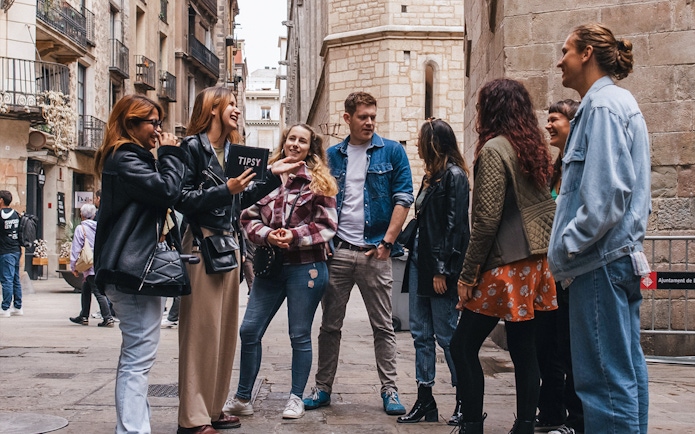 Group enjoying a guided walking tour in a historic Barcelona street.