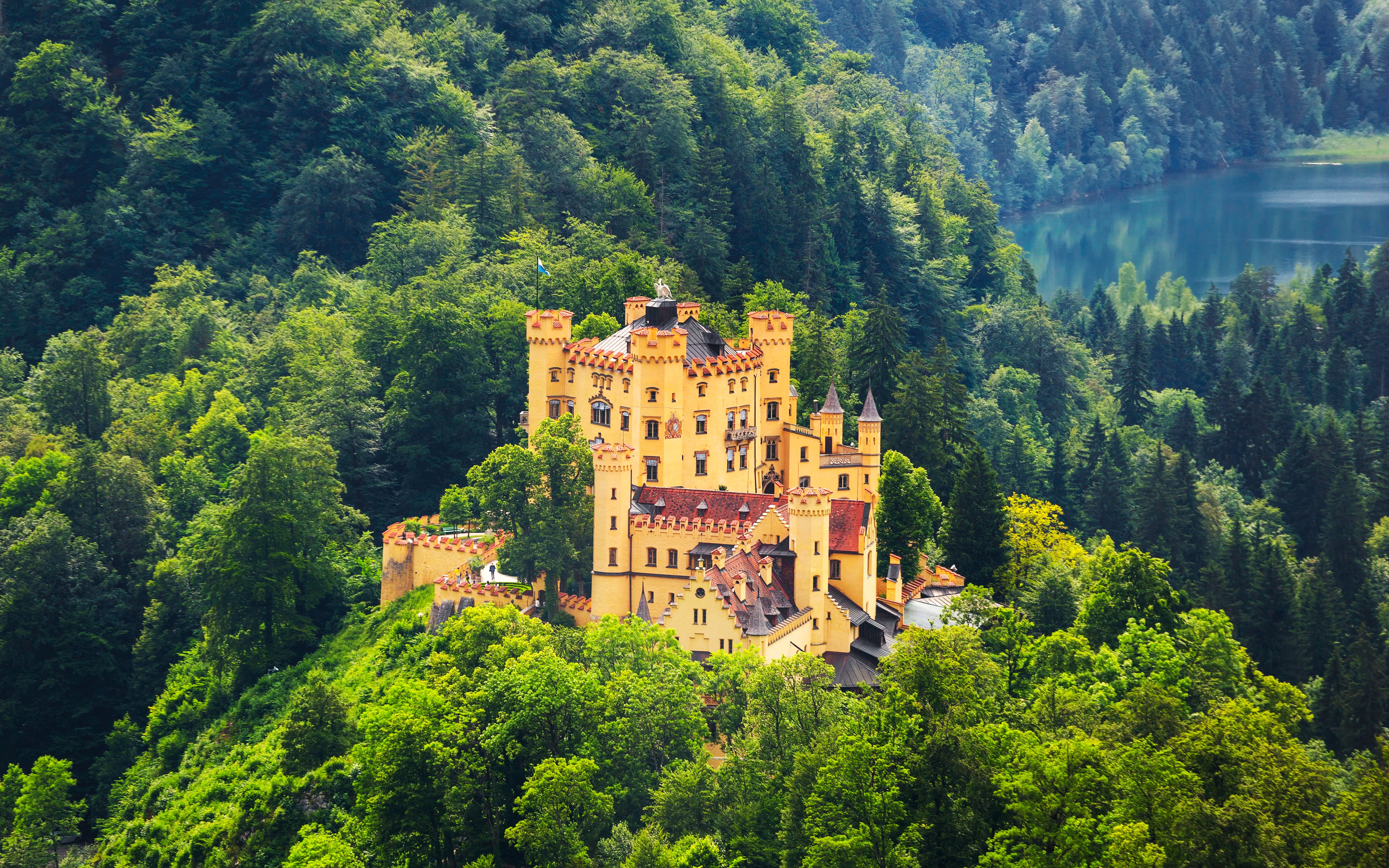 Hohenschwangau Castle surrounded by lush forest, Bavaria, Germany.