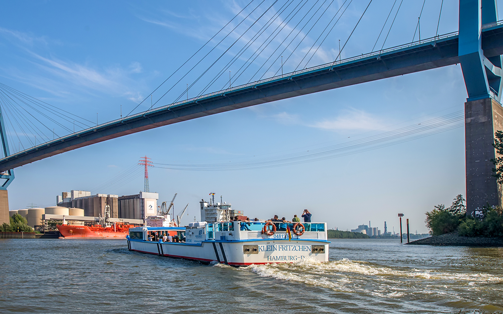 Tour boat under Köhlbrand Bridge in Hamburg harbor.