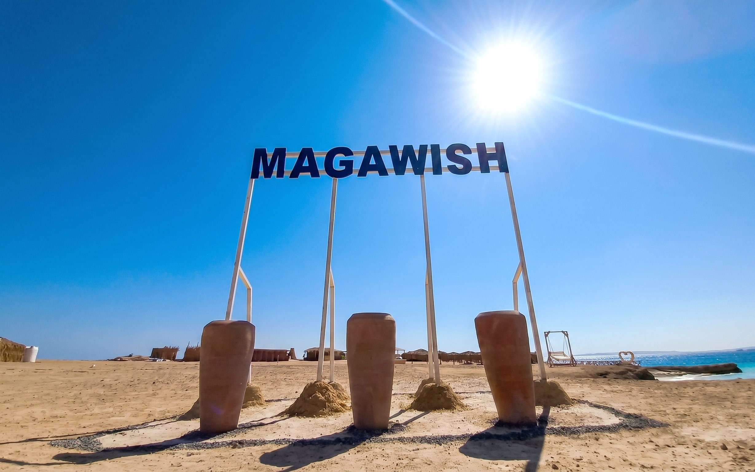 Magawish Island beach with sign under clear sky, Hurghada, Egypt.