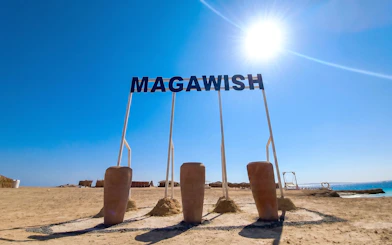Magawish Island beach with sign under clear sky, Hurghada, Egypt.