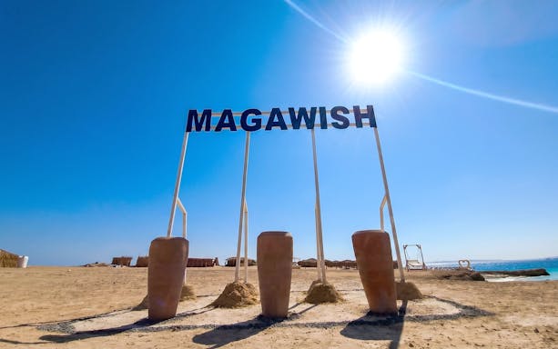Magawish Island beach with sign under clear sky, Hurghada, Egypt.