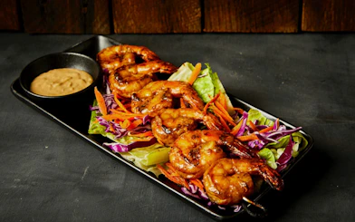 Grilled shrimp skewers with salad and dipping sauce, Cairns Aquarium Night Tour dinner option.