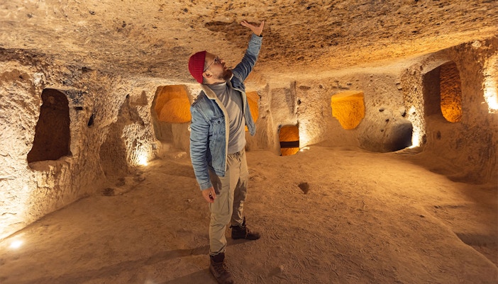 Man exploring Kaymakli Underground City in Cappadocia, Turkey.