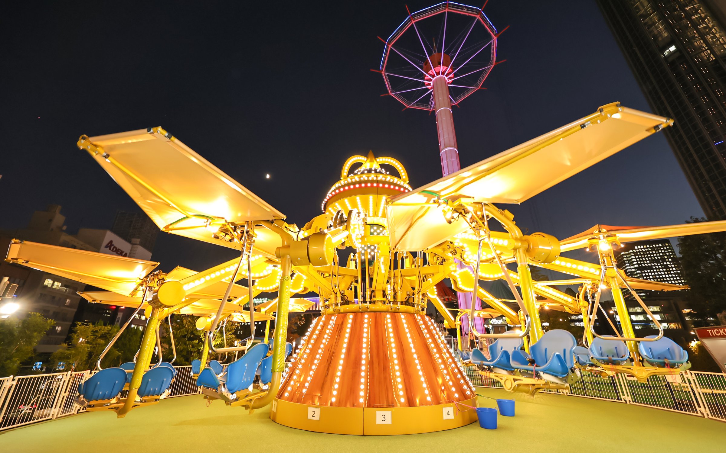 Amusement ride illuminated at night in Tokyo Dome City.