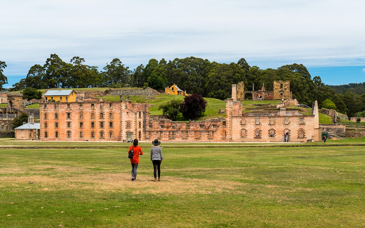 Visitors walking towards the historic ruins at Port Arthur Historic Site, Tasmania.