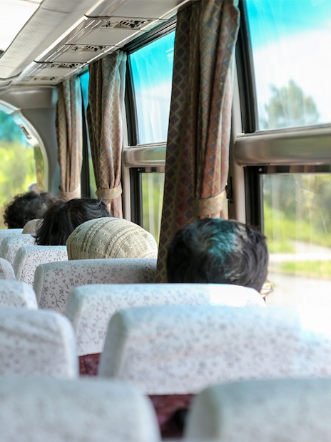 Passengers seated inside an AC coach bus for Nara and Kyoto One-Day Tour.