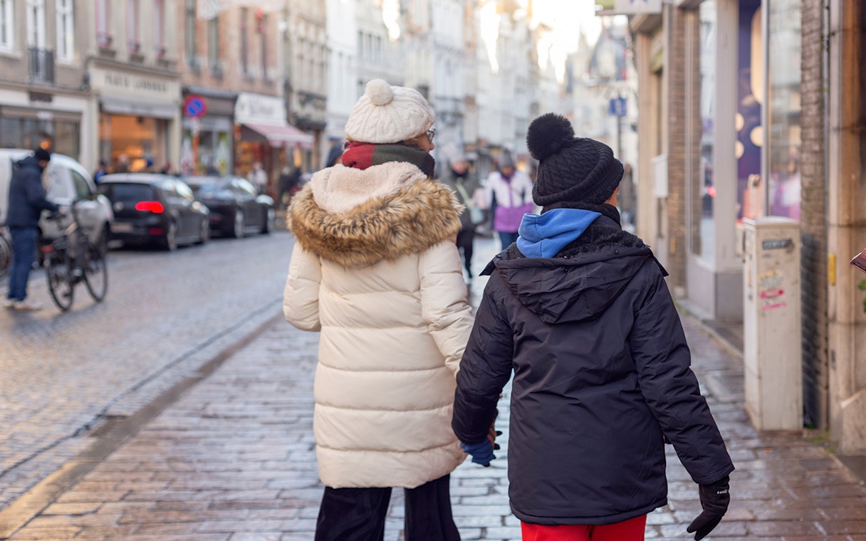 Tourists walking on a cobblestone street in Bruges, Belgium.