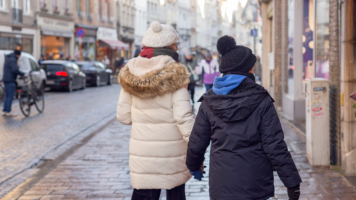 Tourists walking on a cobblestone street in Bruges, Belgium.