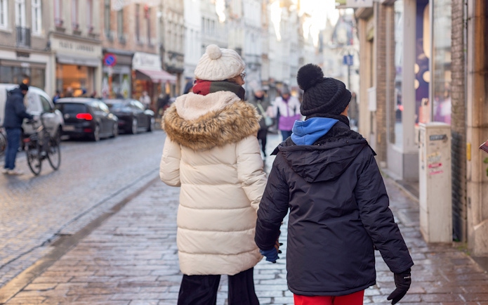 Tourists walking on a cobblestone street in Bruges, Belgium.