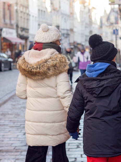 Tourists walking on a cobblestone street in Bruges, Belgium.