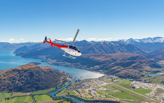 Helicopter flying over Queenstown with view of mountains and lake on Milford Sound Fly-Cruise-Heli Tour.