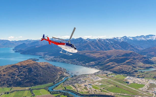 Helicopter flying over Queenstown with view of mountains and lake on Milford Sound Fly-Cruise-Heli Tour.