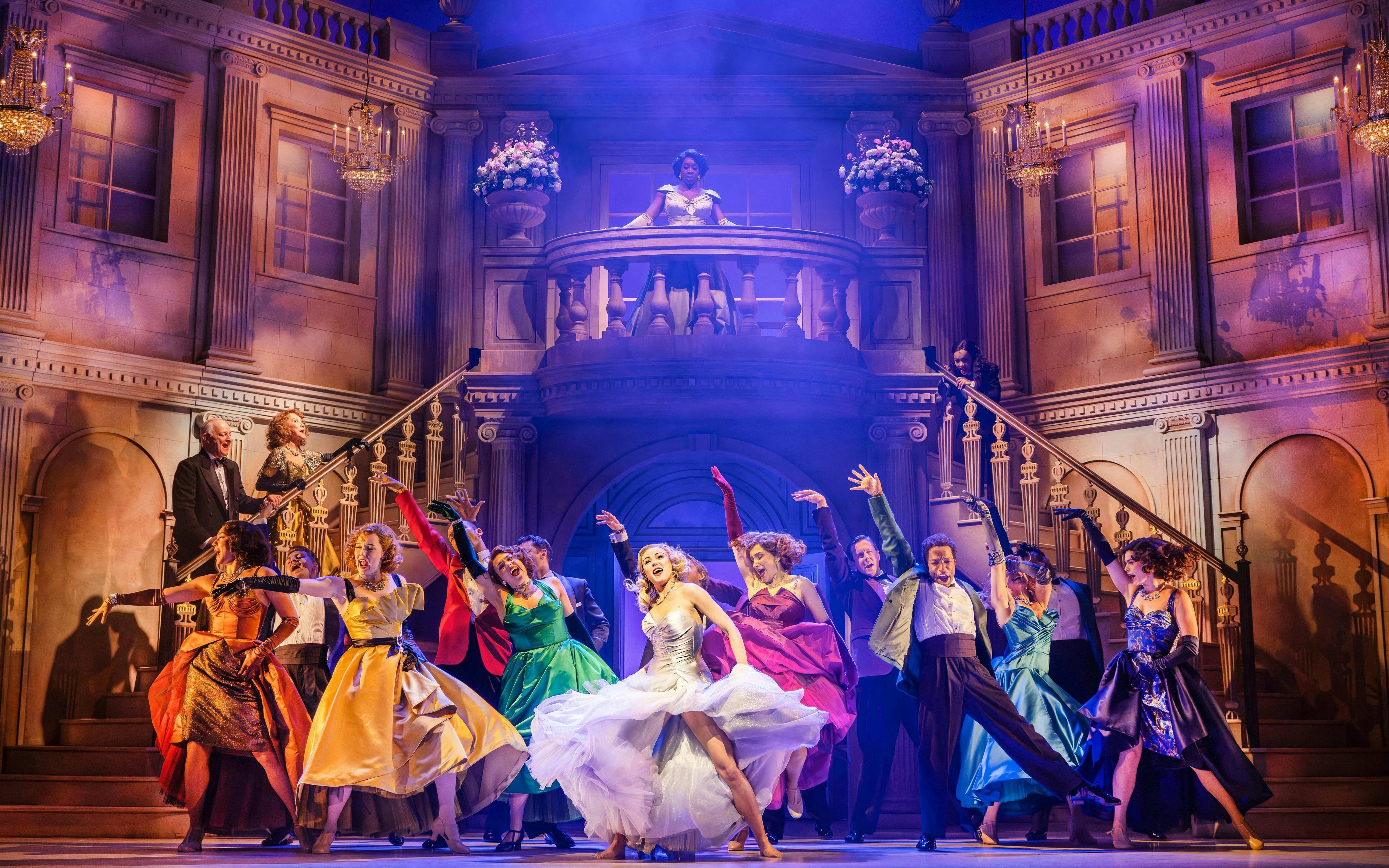 Stage performance of High Society musical in West End theater with dancers in colorful costumes.