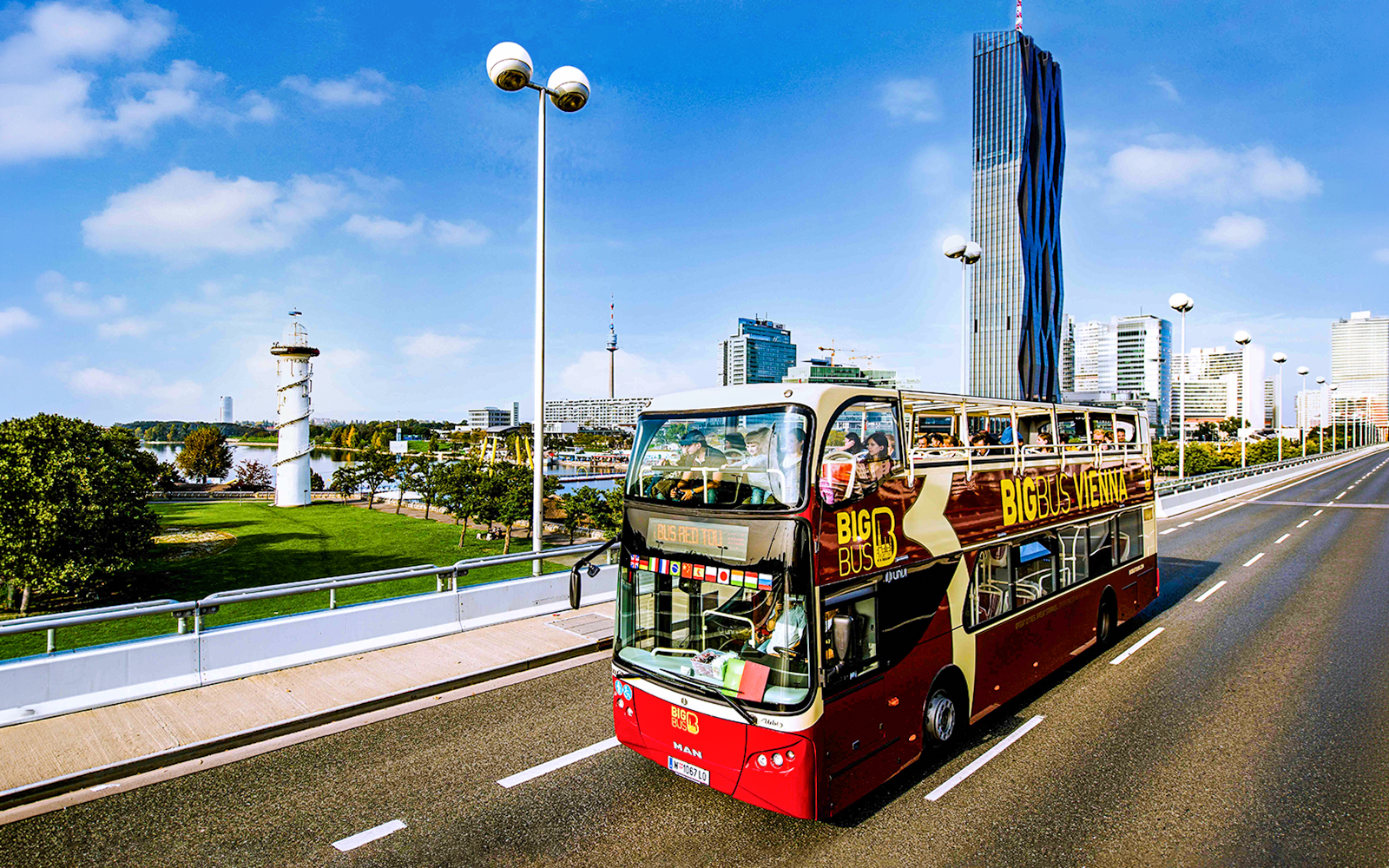 Big Bus tour passing DC Tower 1 in Vienna, showcasing city skyline.