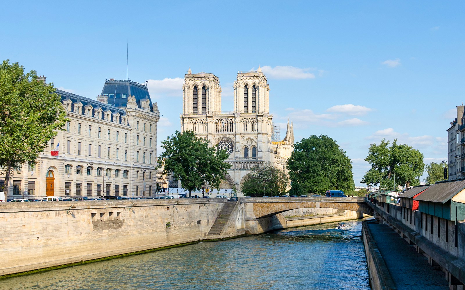 Seine River cruise boat with passengers enjoying French breakfast, Paris landmarks in view.