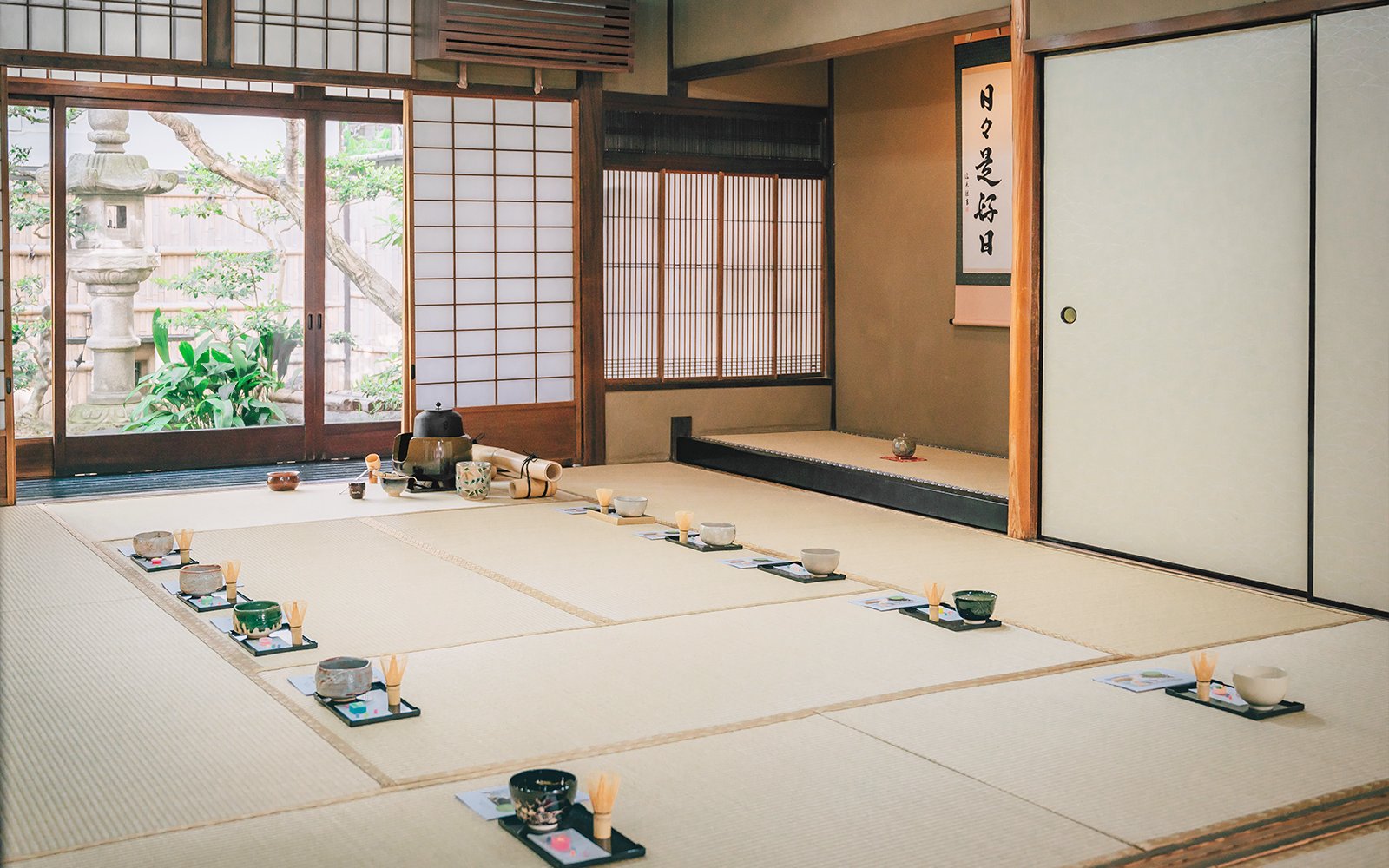 Traditional tea ceremony setup in a 100-year-old Machiya townhouse with tatami mats and tea utensils.