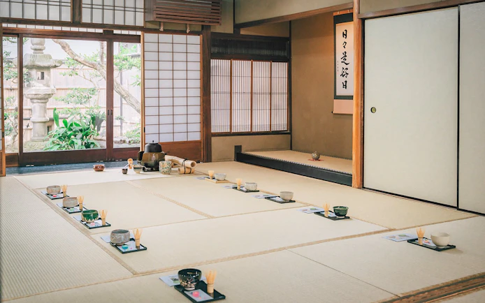 Traditional tea ceremony setup in a 100-year-old Machiya townhouse with tatami mats and tea utensils.
