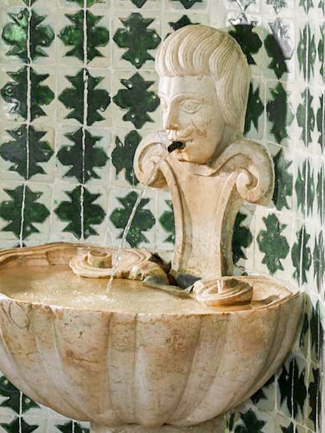 Stone fountain with carved face in the Archers Room, National Palace of Sintra.