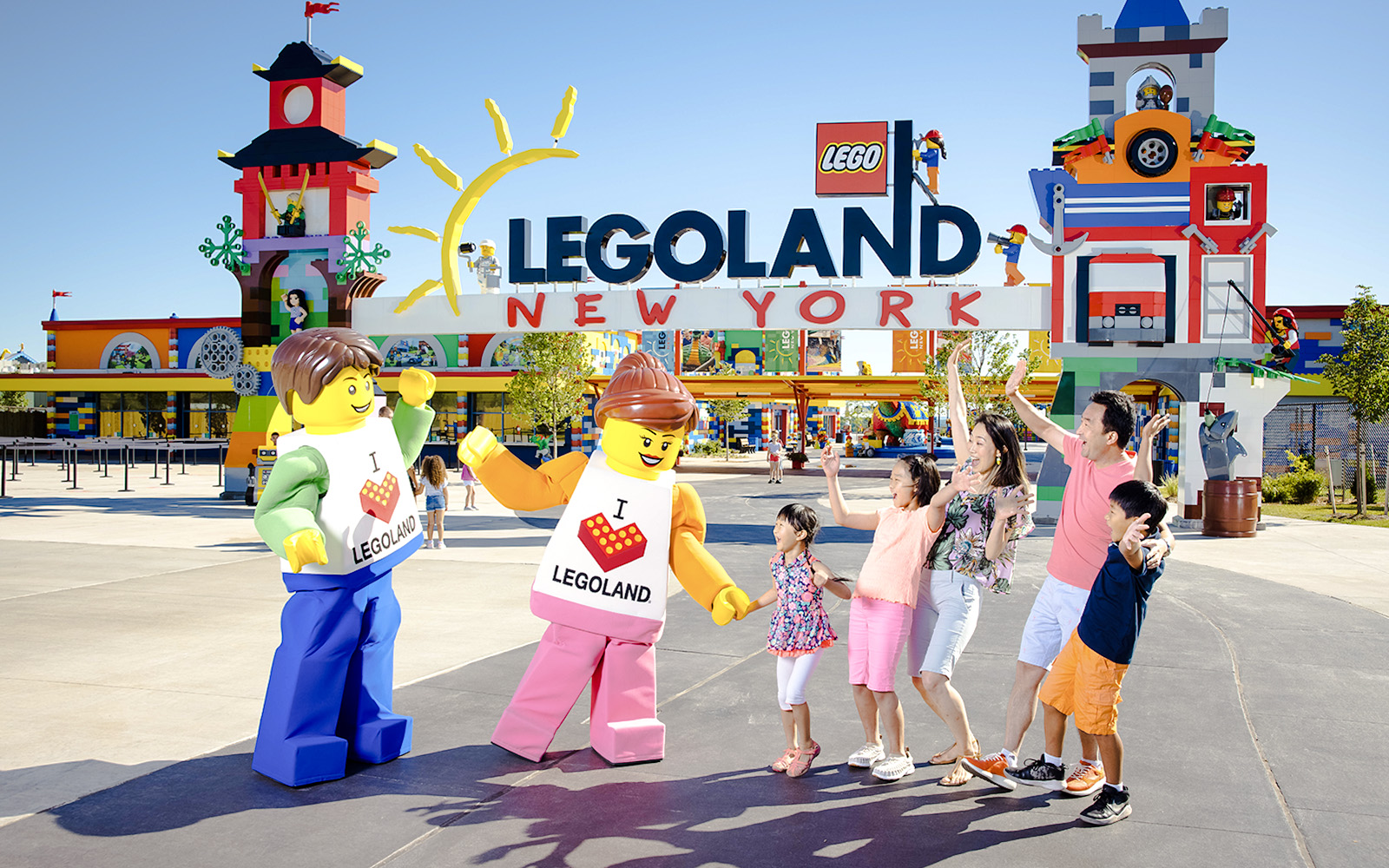 Guests interacting with Lego characters at Legoland New York entrance.