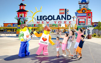 Guests interacting with Lego characters at Legoland New York entrance.