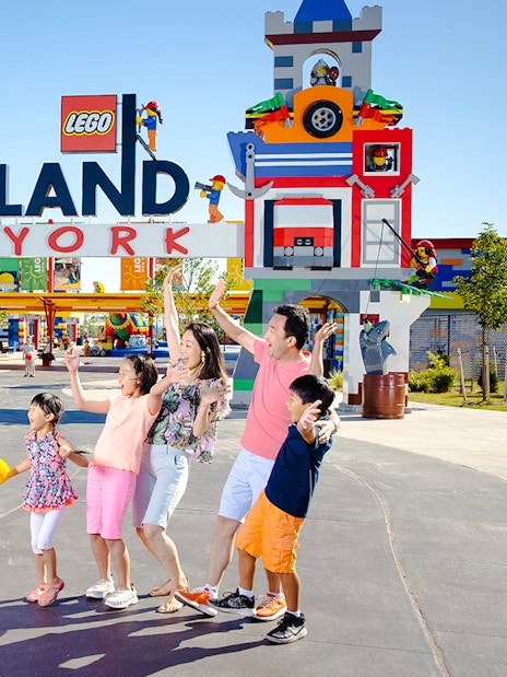 Guests interacting with Lego characters at Legoland New York entrance.