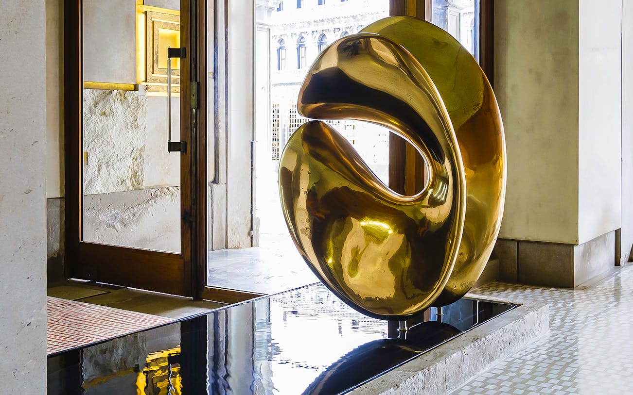 Golden sculpture inside Negozio Olivetti, Venice, near entrance door.