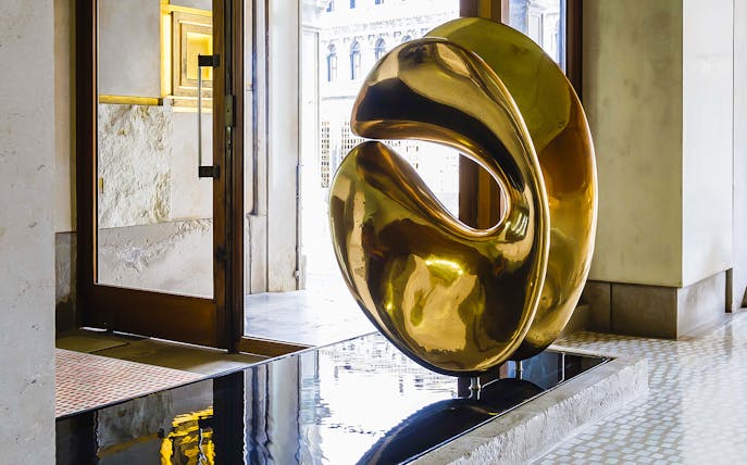 Golden sculpture inside Negozio Olivetti, Venice, near entrance door.