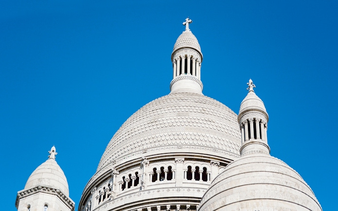 Dome of Sacré-Cœur Basilica against a clear blue sky in Montmartre, Paris.