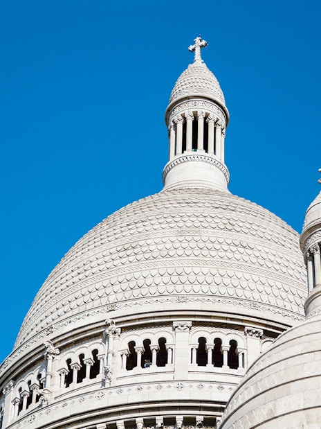 Dome of Sacré-Cœur Basilica against a clear blue sky in Montmartre, Paris.