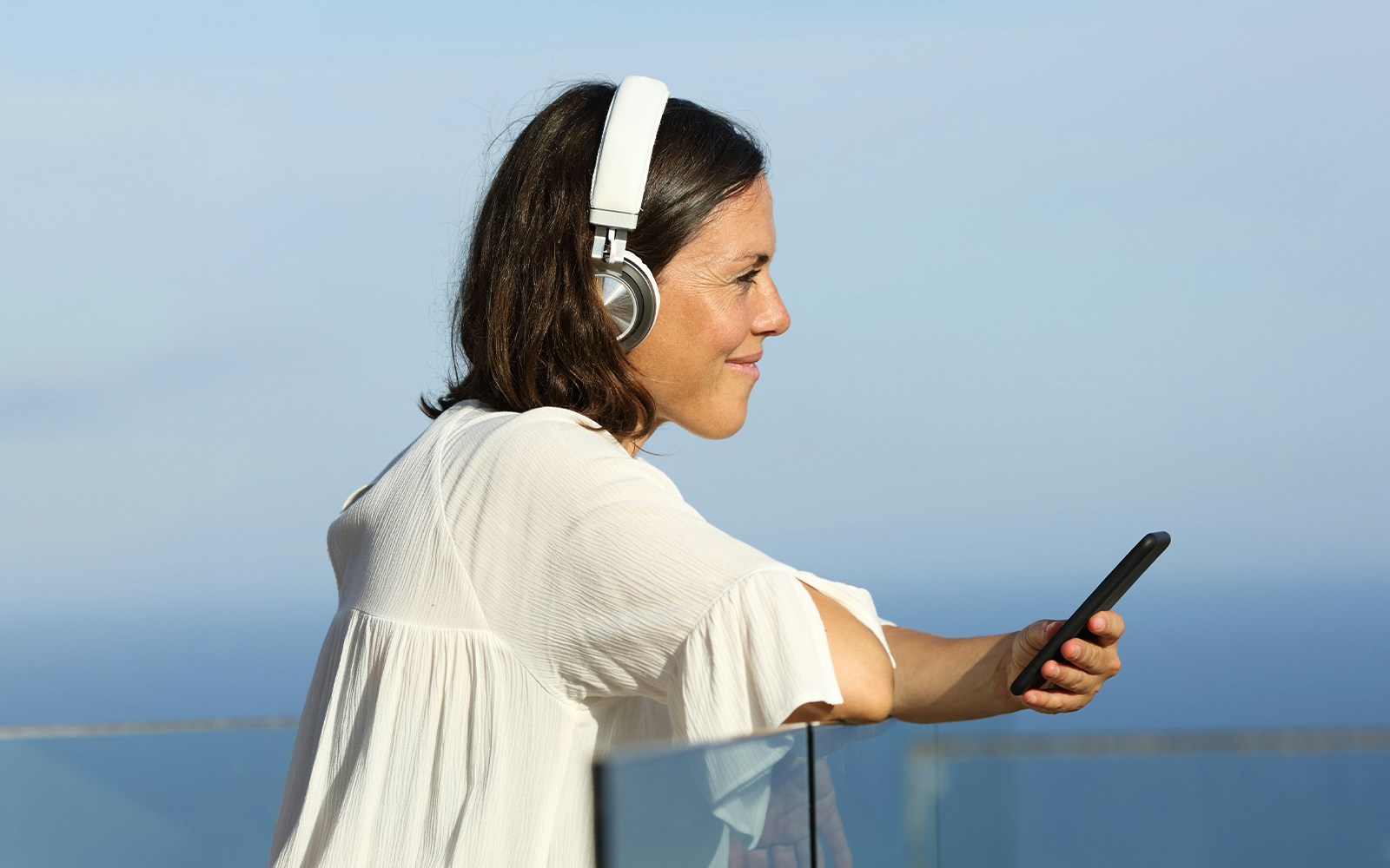 Woman using audio guide on Thames River cruise in London with Westminster view