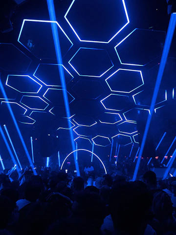 Crowded dance floor at Pacha nightclub with blue hexagonal ceiling lights.
