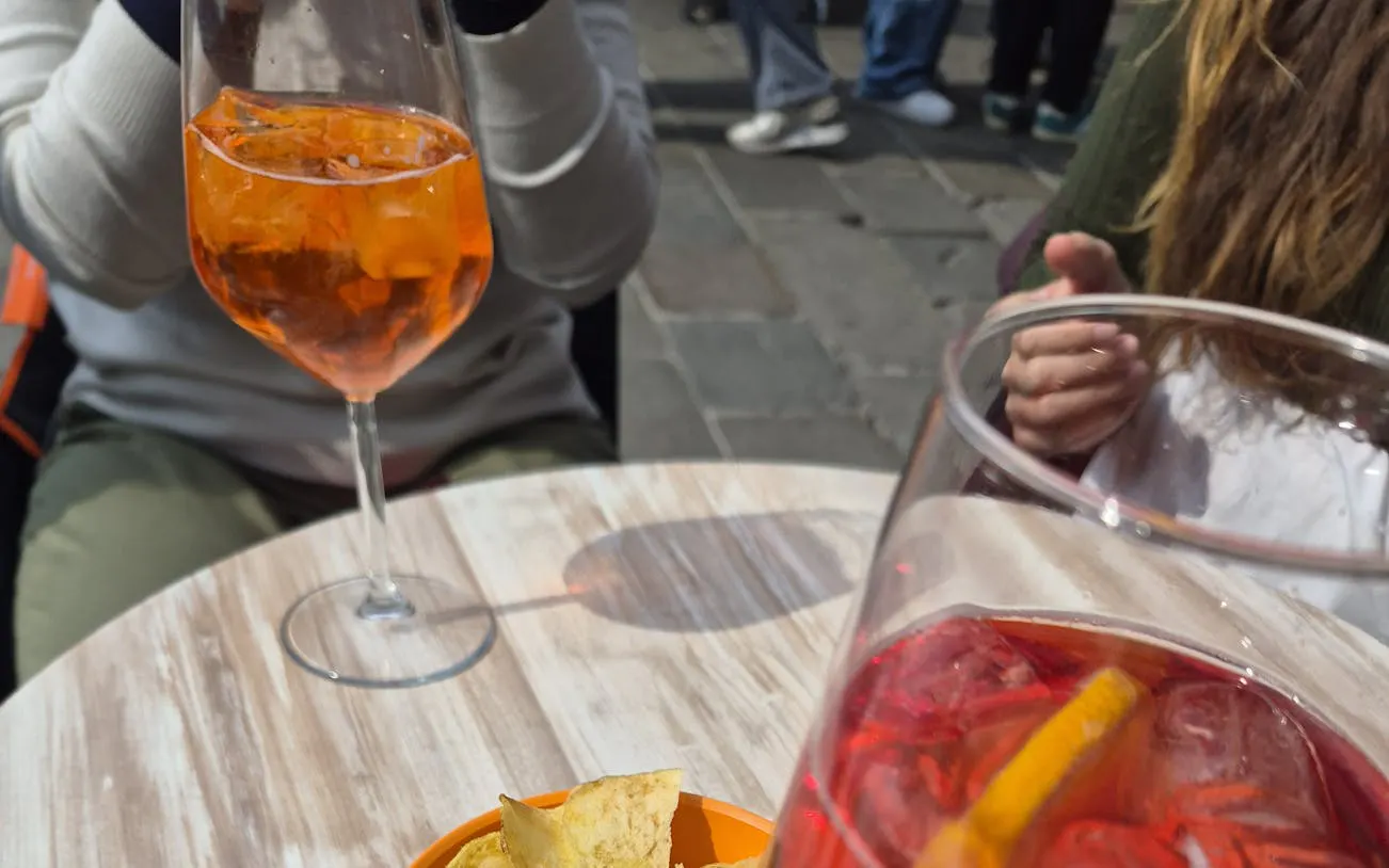 Glasses of Aperol Spritz and snacks on a table during Padova food tour.