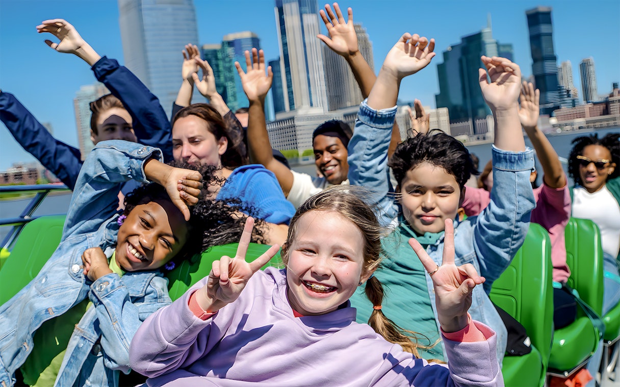 Guests enjoying NYC Speedboat Ride with skyline in background.