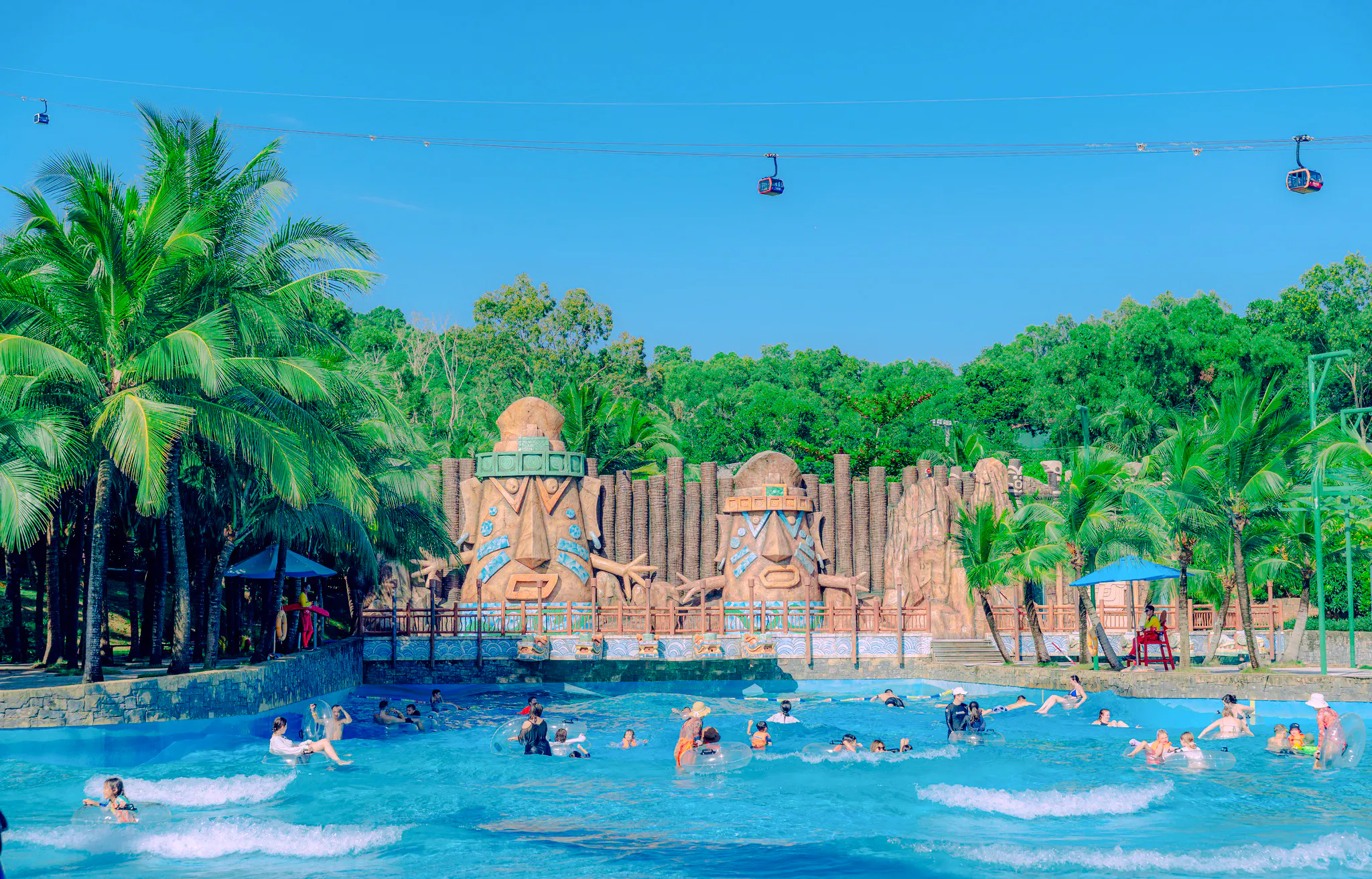 Aquatopia water park with wave pool and statues, Phu Quoc Hon Thom Cable Car visible above.