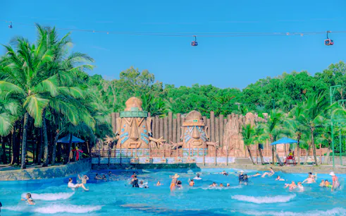 Aquatopia water park with wave pool and statues, Phu Quoc Hon Thom Cable Car visible above.