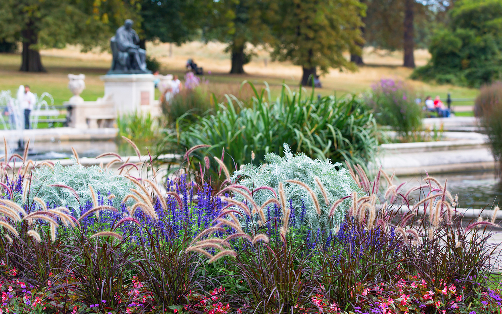 Kensington Palace Italian garden with vibrant flowers and statue in London.