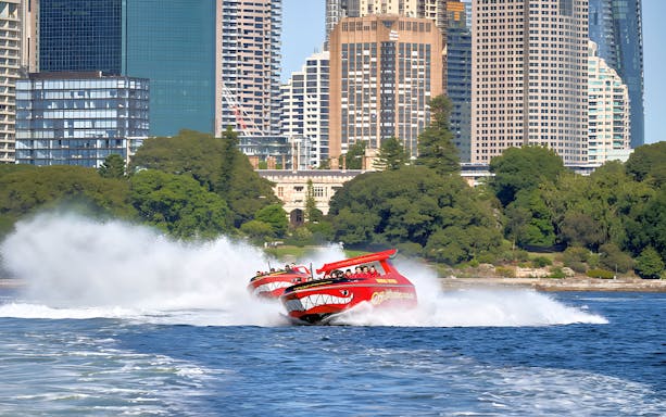 Jet boats speeding on Sydney Harbour with city skyline in the background.