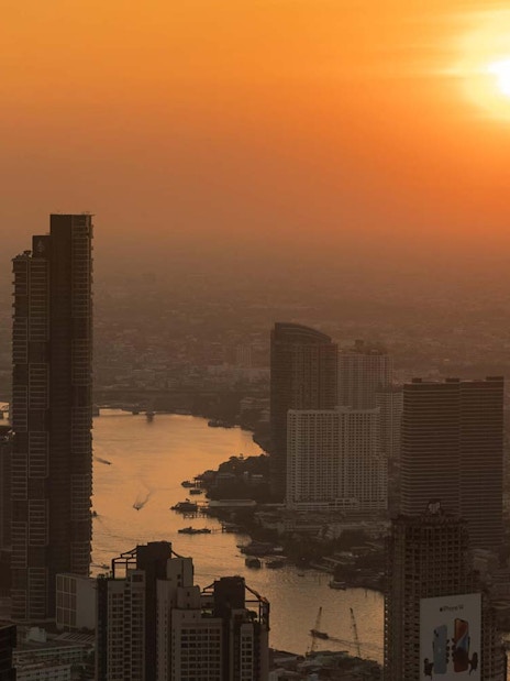 Bangkok skyline view from Mahanakhon SkyWalk at sunset.