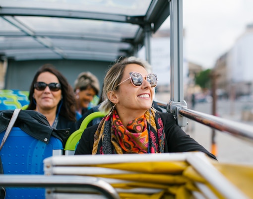 Woman enjoying a hop-on hop-off bus tour in Madina.