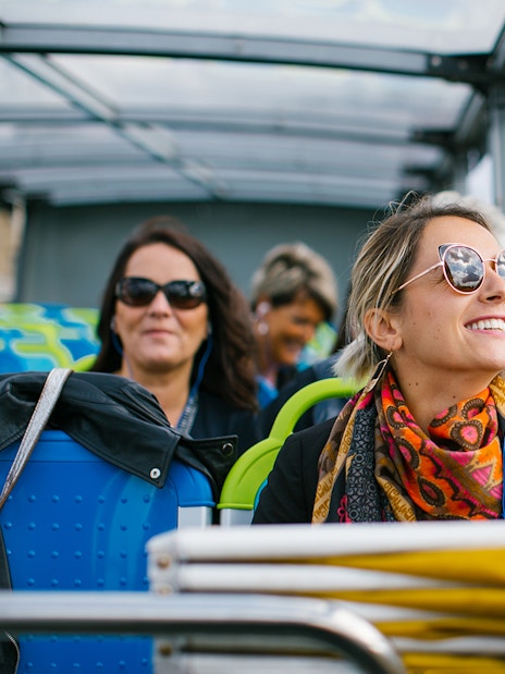 Woman enjoying a hop-on hop-off bus tour in Paris.