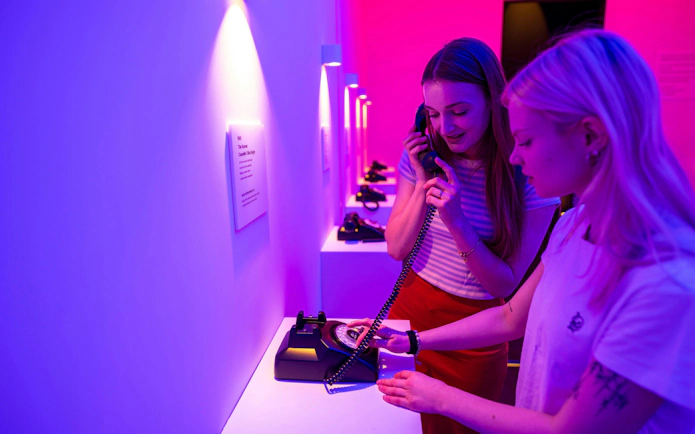 Visitors using vintage phones at JSA Museum exhibit during Half-Day DMZ Tour from Seoul.