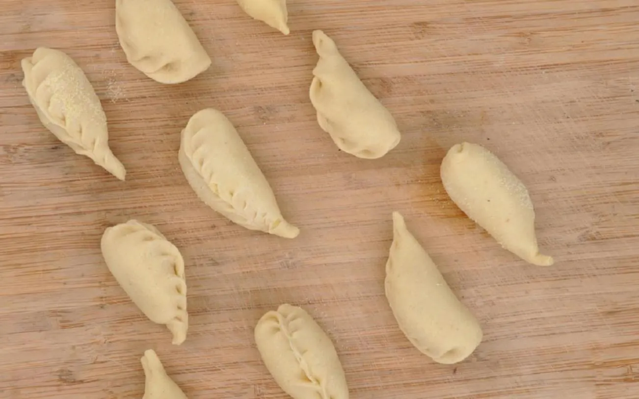Culurgiones pasta on a wooden board during a cooking class in Cagliari.