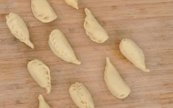 Culurgiones pasta on a wooden board during a cooking class in Cagliari.