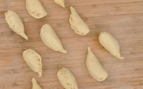 Culurgiones pasta on a wooden board during a cooking class in Cagliari.