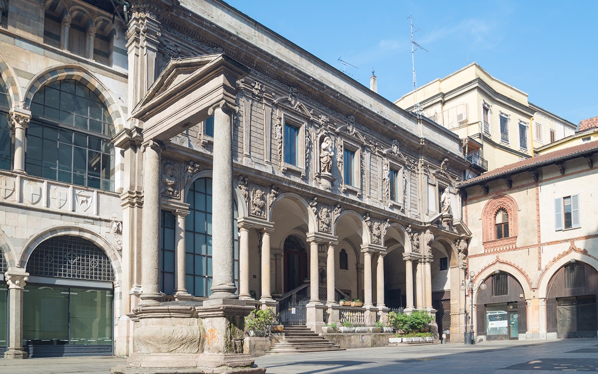 Historic architecture at Mercanti Square in Milan, featuring ornate columns and arches.