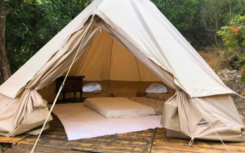 Glamping tent with bed in forest setting, Castiadas, Cagliari.