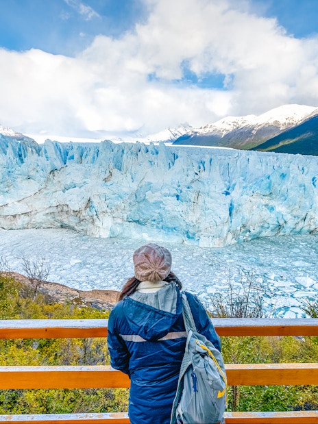 Visitor overlooking Perito Moreno Glacier from viewing deck in Argentina.